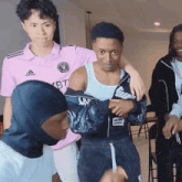 a man in a pink adidas shirt holds another man
