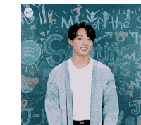 a young man is standing in front of a chalkboard that says spotify