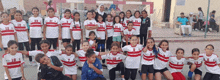 a group of children are posing for a picture and one of their shirts says ' a ' on it