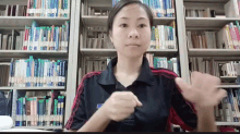 a woman stands in front of a bookshelf with a few books on it including one that says ' biology '