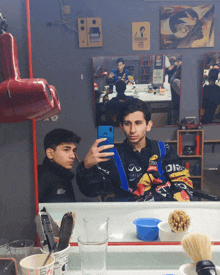 two boys are taking a selfie in front of a mirror with one wearing a jacket that says infiniti