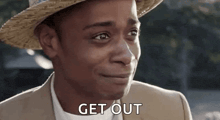 a man wearing a straw hat and a suit is smiling and saying `` get out '' .