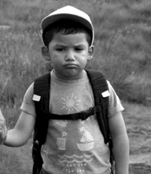 a little boy wearing a backpack and a shirt that says i can see the sea