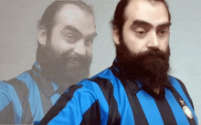 a man with a beard is wearing a blue and black striped shirt with a star on it