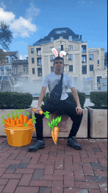 a man wearing bunny ears sits on a brick wall with carrots in front of him