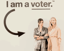 two women are standing in front of a sign that says i am a voter