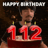 a man stands in front of a cake with candles in the shape of the number 112