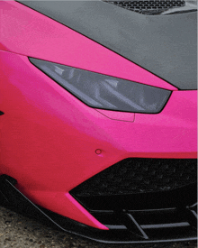 a pink car with a black hood and black headlights