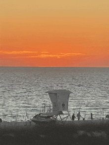 a lifeguard tower on a beach at sunset