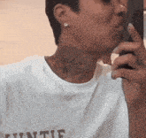 a man with a tattoo on his neck is wearing a white t-shirt that says ' infinite ' on it