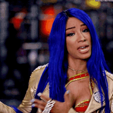 a woman with blue hair is wearing a gold outfit