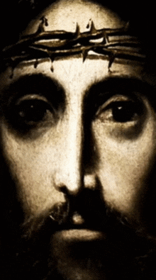 a close up of jesus ' face with a crown of thorns