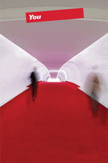 a blurred image of people walking down a red carpet under a sign that says " you "