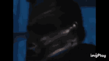 a close up of a person 's face in the dark with a blue background .