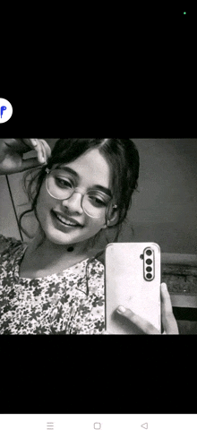 a black and white photo of a girl taking a selfie with her phone .