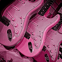 a row of pink electric guitars with knobs that say volume and tone