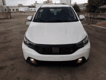 a white fiat car is parked in a parking garage