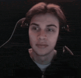 a young man wearing headphones is sitting in a chair and making a funny face .