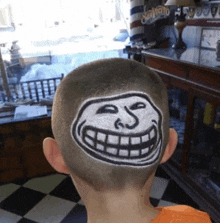 a boy has a troll face drawn on his head