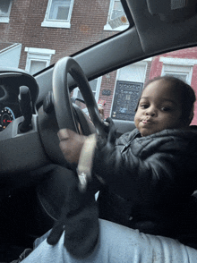 a little boy is sitting in a car with a sticker on the windshield that says ' safety ' on it