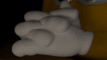 a close up of a cartoon character 's hand in a white glove