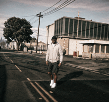 a man walking down a street with a building in the background that has a sign on it that says " no parking "