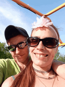 a man and a woman wearing sunglasses and a flower on their head