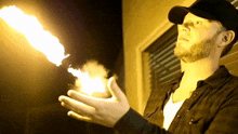 a man in a black shirt is holding a torch in his hand