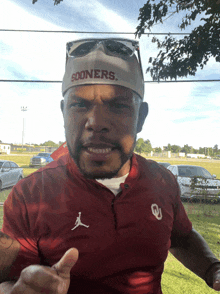 a man wearing a sooners hat and an oklahoma shirt