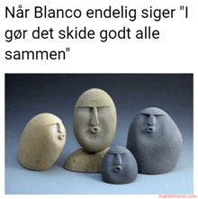 a group of rocks with faces carved into them with a caption that says " nar blanco endelig siger "