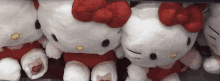 a row of hello kitty stuffed animals with red bows on their heads