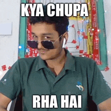 a man wearing sunglasses and ear buds is making a funny face and says kya chupa rha hai .