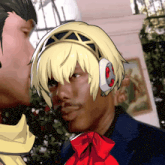 a man wearing headphones and a red bow looks at another man