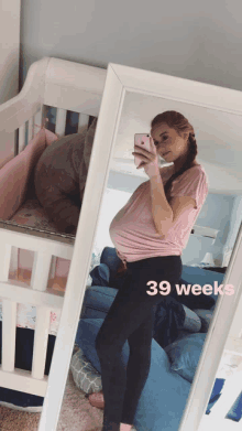 a pregnant woman is taking a picture of herself in a mirror with the words 39 weeks written on the bottom