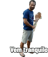 a man in a blue shirt is holding a stick and the words vem tranquilo are above him