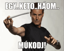 a man in a black shirt is holding something in his hand with the words egy keto haom mukodj in white letters