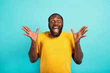 a man in a yellow t-shirt is laughing with his mouth open and his hands in the air .