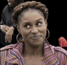 a woman with a braided headband and hoop earrings