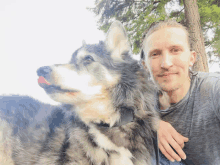 a man and his dog are posing for a picture and the dog is licking his nose