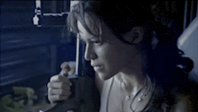 a woman is looking out a window while holding a cup