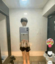 a person taking a picture of themselves in front of a mirror with a sticker on the wall that says 11k