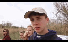 a group of people are standing in a field and one of them is wearing a hat that says ' tiger ' on it