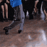 a person in a blue shirt is dancing in front of a crowd of people .