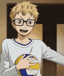 a young boy with glasses is holding a volleyball in his hand