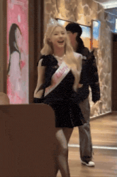 a woman wearing a sash that says happy