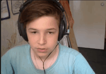 a young boy wearing headphones and a blue shirt looks at the camera