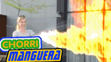 a woman is standing in front of a fire with a sign that says " chorri manguera "