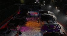 a bunch of cars are parked on a cobblestone street with purple lights