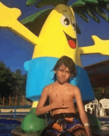 a young boy is sitting in front of a large inflatable man .