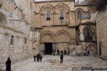 a group of people walking in front of a building